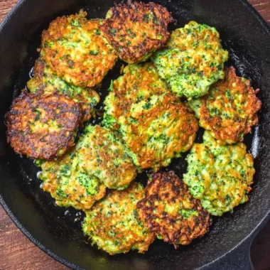 Crispy homemade broccoli fritters on a plate garnished with herbs