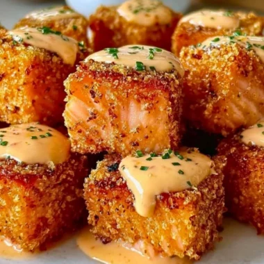 Plate of crispy Bang Bang Salmon bites garnished with fresh herbs