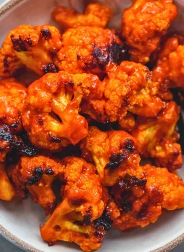 Plate of easy Buffalo Cauliflower bites garnished with celery and ranch dip