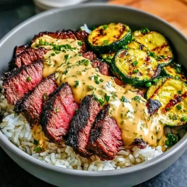 Grilled steak bowl with sauce and grilled zucchini served in a colorful dish