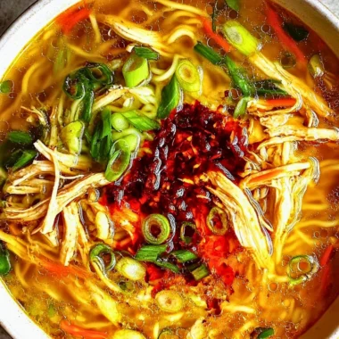 Bowl of Classic Ginger Garlic Chicken Noodle Soup with fresh herbs and chicken