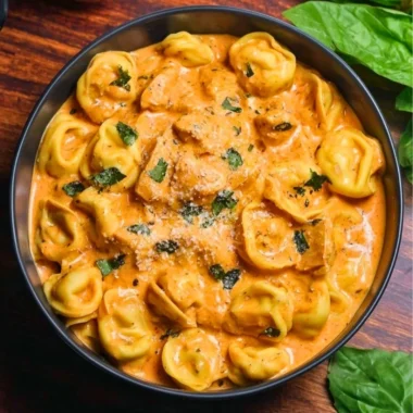 Delicious CrockPot Chicken Tortellini in a bowl topped with herbs