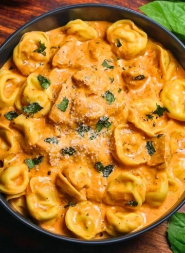 Delicious CrockPot Chicken Tortellini in a bowl topped with herbs