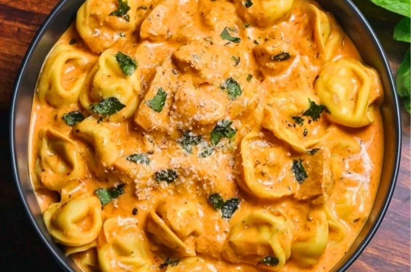Delicious CrockPot Chicken Tortellini in a bowl topped with herbs