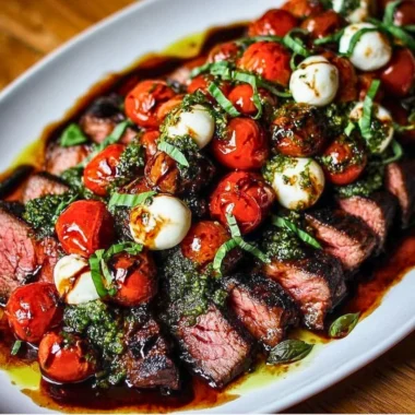Grilled flank steak caprese topped with fresh mozzarella, tomatoes, and basil.