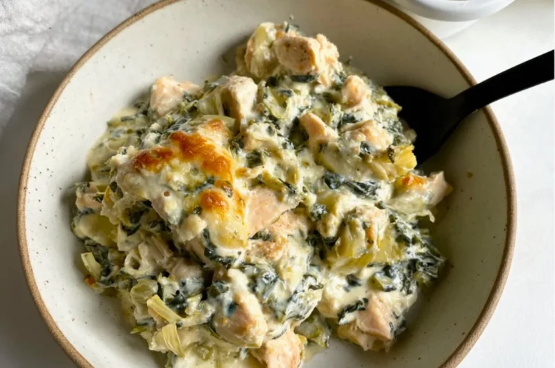 High-protein spinach artichoke chicken casserole in a baking dish