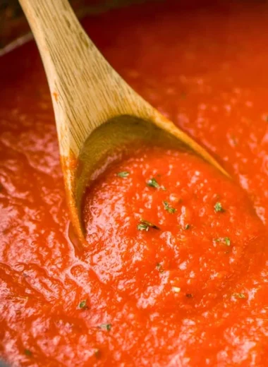 A bowl of homemade marinara sauce with fresh tomatoes and herbs