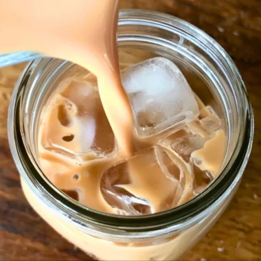 A refreshing Iced English Tea Latte topped with frothy milk and ice cubes.