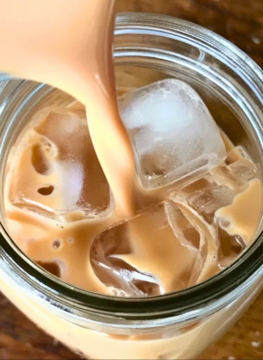 A refreshing Iced English Tea Latte topped with frothy milk and ice cubes.