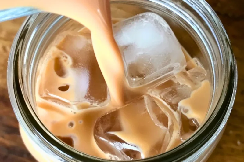 A refreshing Iced English Tea Latte topped with frothy milk and ice cubes.