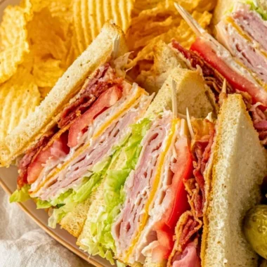 Delicious club sandwich with layers of turkey, bacon, lettuce, and tomato.