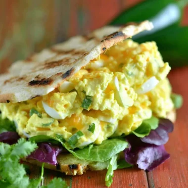 Jalapeno Cheddar Egg Salad served in a bowl garnished with fresh herbs