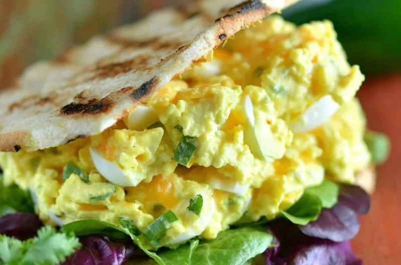 Jalapeno Cheddar Egg Salad served in a bowl garnished with fresh herbs