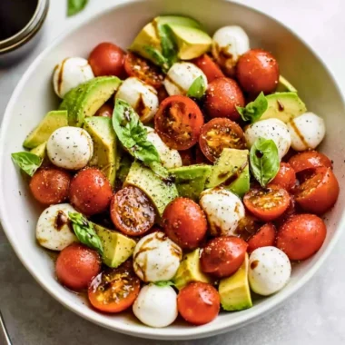 Light avocado caprese salad with fresh mozzarella and tomatoes