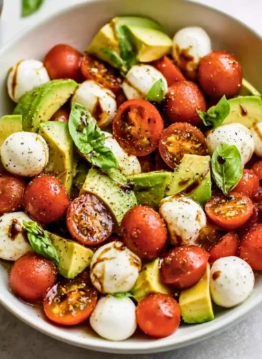 Light avocado caprese salad with fresh mozzarella and tomatoes