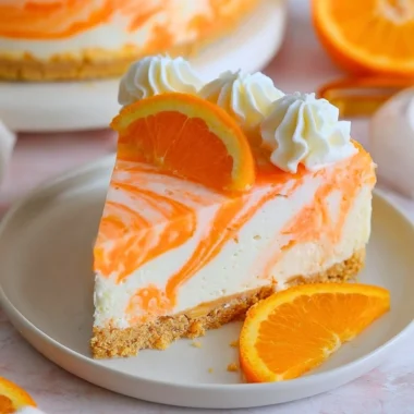 No-Bake Orange Creamsicle Cheesecake topped with orange slices and whipped cream