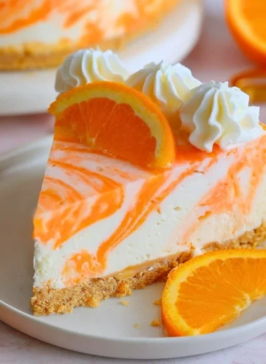 No-Bake Orange Creamsicle Cheesecake topped with orange slices and whipped cream