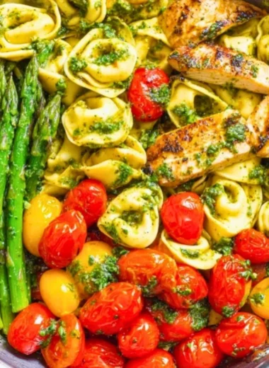 One-Pan Pesto Chicken with tortellini and mixed vegetables in a skillet