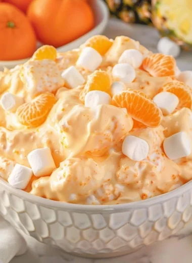 Delicious Orange Fluff Salad served in a bowl, featuring fluffy orange goodness.