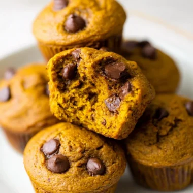 Homemade pumpkin protein muffins on a wooden table, healthy snack option.