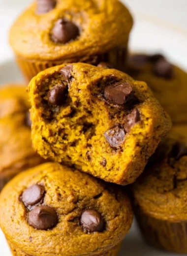 Homemade pumpkin protein muffins on a wooden table, healthy snack option.