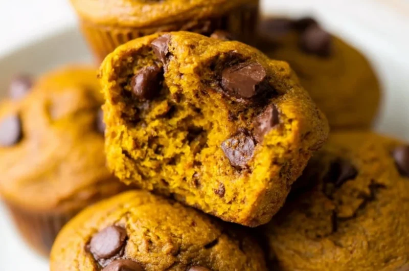 Homemade pumpkin protein muffins on a wooden table, healthy snack option.