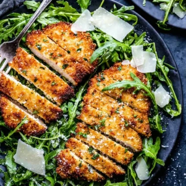 Crispy air-fryer chicken breast on a plate garnished with herbs