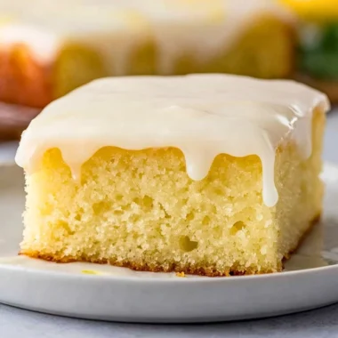 Cozy Lemonade Poke Cake topped with fresh lemon slices and whipped cream