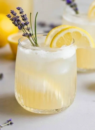 A refreshing Coconut Lavender Lemonade Mocktail garnished with lavender sprigs and lemon.