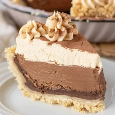 Costco Peanut Butter Chocolate Cream Pie topped with chocolate drizzle and peanuts.
