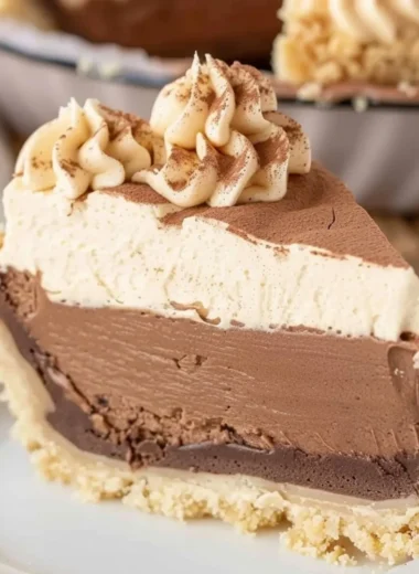 Costco Peanut Butter Chocolate Cream Pie topped with chocolate drizzle and peanuts.