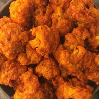 Crispy baked buffalo cauliflower wings served on a plate with dipping sauce.