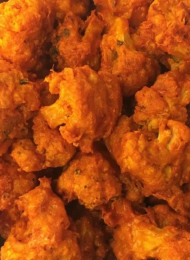 Crispy baked buffalo cauliflower wings served on a plate with dipping sauce.