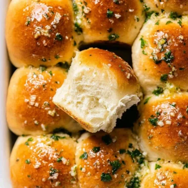 Delicious freshly baked garlic bread rolls on a wooden table