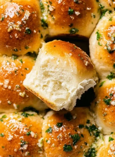 Delicious freshly baked garlic bread rolls on a wooden table