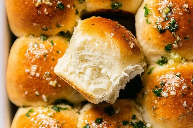 Delicious freshly baked garlic bread rolls on a wooden table