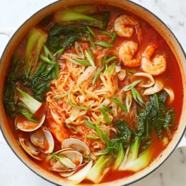 A steaming bowl of Jjamppong, a spicy Korean seafood noodle soup with vibrant ingredients.