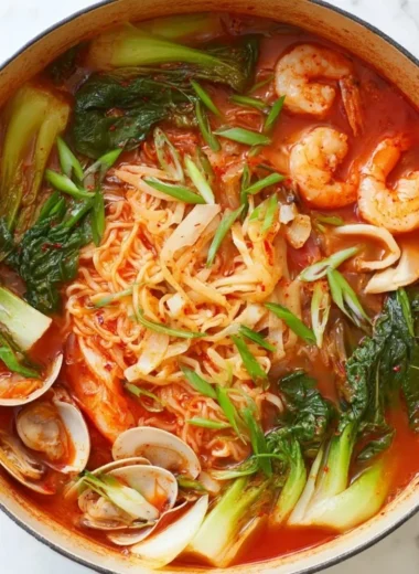 A steaming bowl of Jjamppong, a spicy Korean seafood noodle soup with vibrant ingredients.