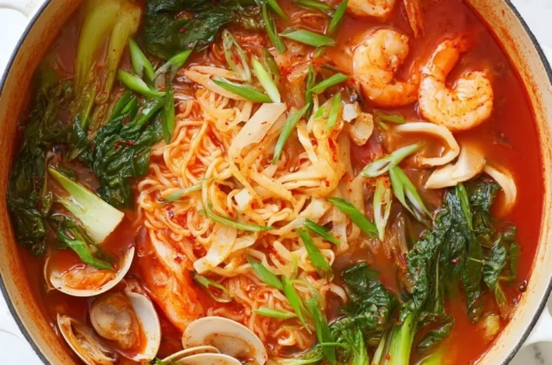 A steaming bowl of Jjamppong, a spicy Korean seafood noodle soup with vibrant ingredients.