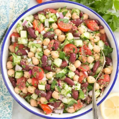 A colorful Mediterranean bean salad with fresh vegetables and herbs.