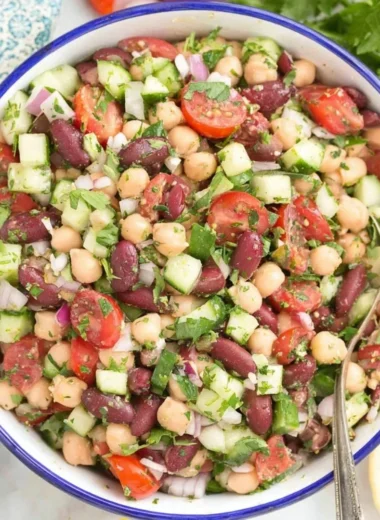A colorful Mediterranean bean salad with fresh vegetables and herbs.