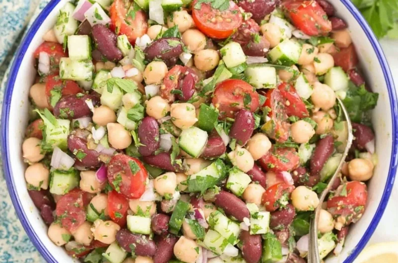 A colorful Mediterranean bean salad with fresh vegetables and herbs.