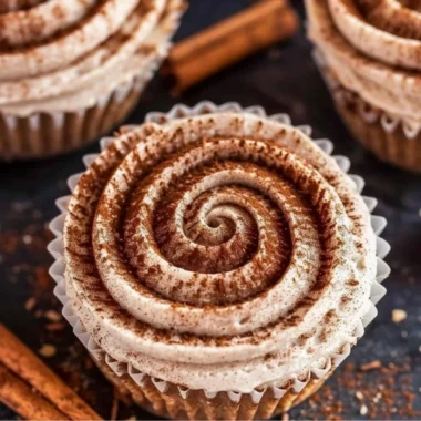 Mini no bake cinnamon roll cheesecakes topped with icing and cinnamon swirl.