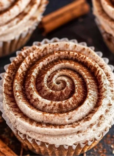 Mini no bake cinnamon roll cheesecakes topped with icing and cinnamon swirl.