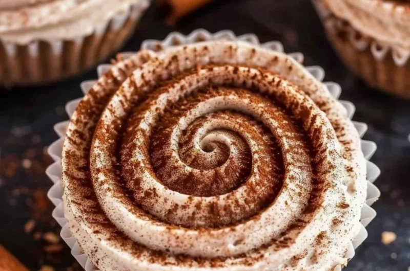 Mini no bake cinnamon roll cheesecakes topped with icing and cinnamon swirl.