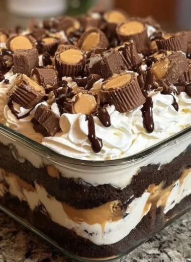 No-bake peanut butter chocolate dessert in a serving dish topped with chocolate drizzle