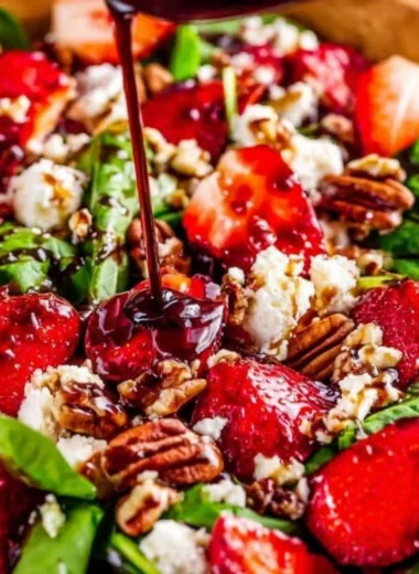 Spinach Strawberry Salad with Pecans garnished with fresh berries and nuts