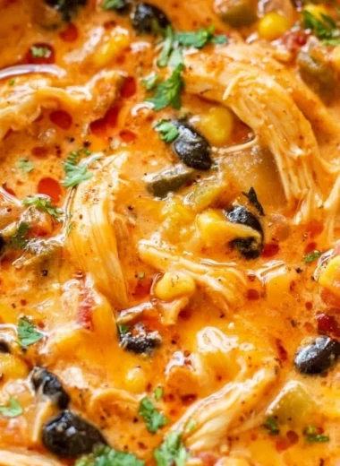 A bowl of delicious Chicken Enchilada Soup topped with cheese and cilantro.