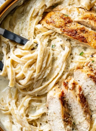 Delicious plate of Chicken Fettuccine Alfredo with creamy sauce and grilled chicken